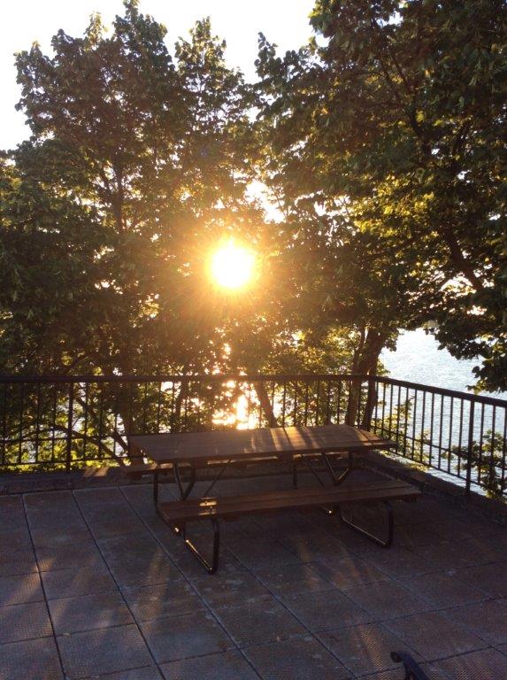 A picnic table on a patio with a sunset