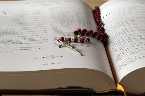 An open bible with rosary ion top
